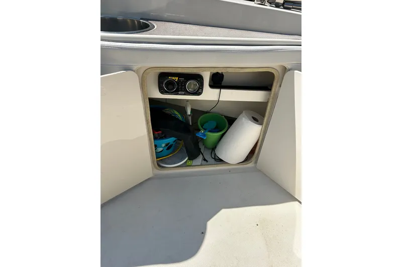 Slide: The Image of Open storage compartment on 2010 Sea Ray 260 Sundeck boat with various items inside. - 30