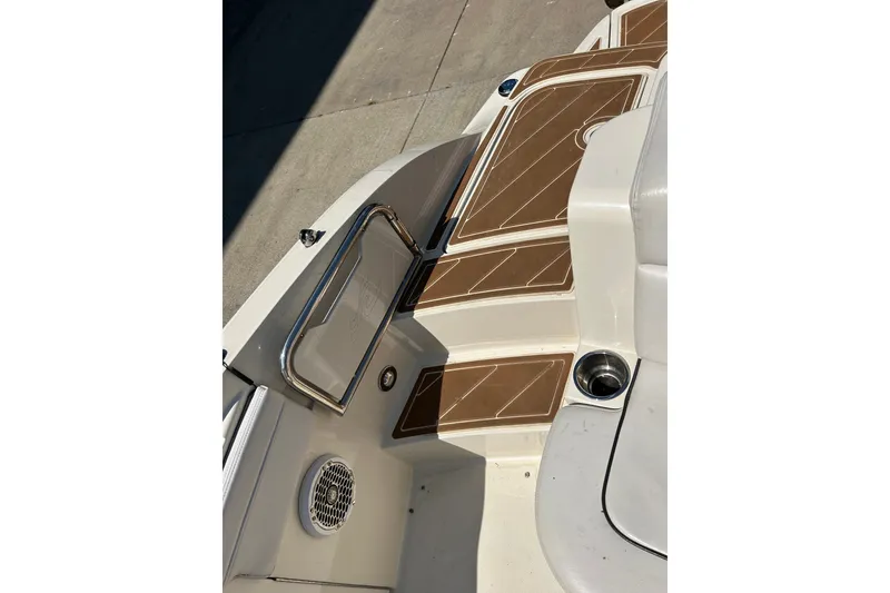 Slide: The Image of 2010 Sea Ray 260 Sundeck boat interior with brown and white seating and cup holder. - 33