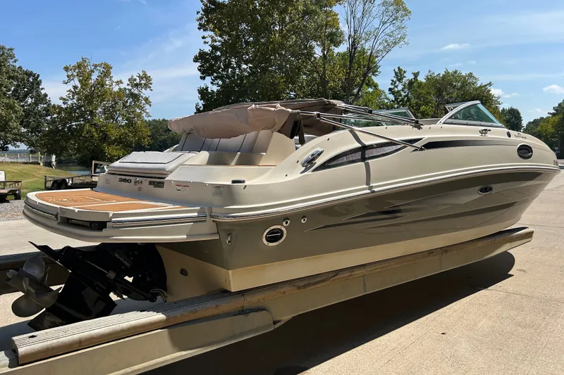 Slide: The Image of 2010 Sea Ray 260 Sundeck boat on trailer, parked outdoors under clear sky. - 8