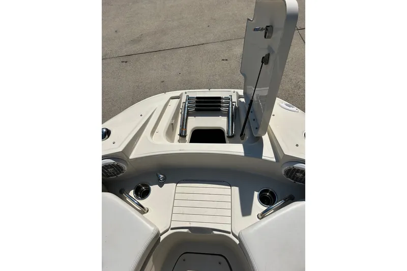 Slide: The Image of 2010 Sea Ray 260 Sundeck boat interior with open storage compartment and cup holders. - 22