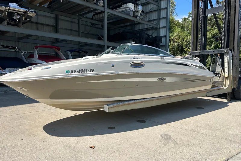 Slide: The Image of 2010 Sea Ray 260 Sundeck boat on a lift in a storage facility. - 13