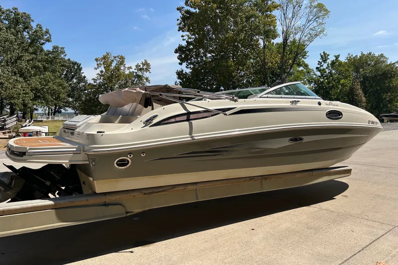 Slide: The Image of 2010 Sea Ray 260 Sundeck boat on trailer, surrounded by trees and clear sky. - 9