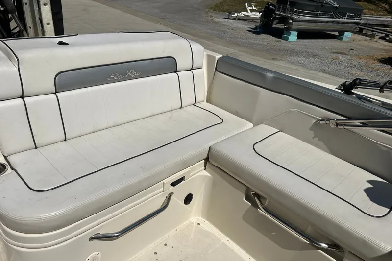 Slide: The Image of 2010 Sea Ray 260 Sundeck interior seating with white upholstery and stainless steel handles. - 31