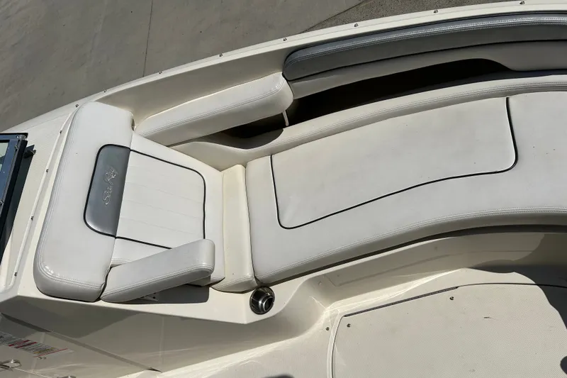 Slide: The Image of 2010 Sea Ray 260 Sundeck interior with white cushioned seating and sleek design. - 25