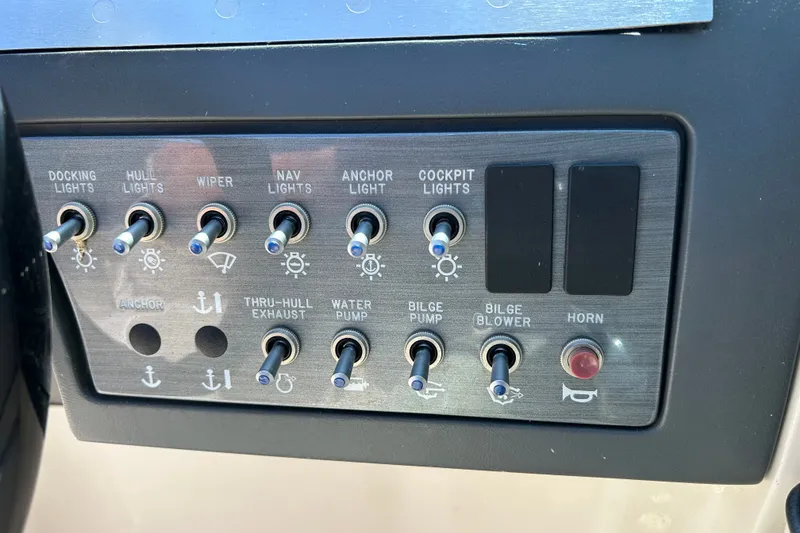 Slide: The Image of Control panel of a 2010 Sea Ray 260 Sundeck boat with various switches. - 28