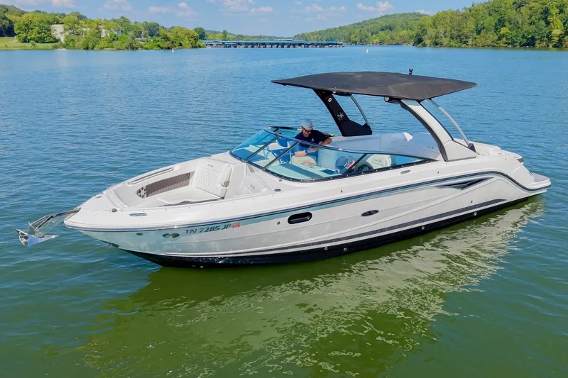 Slide: The Image of 2019 Sea Ray SLX 280 boat cruising on a scenic lake under a clear blue sky. - 4