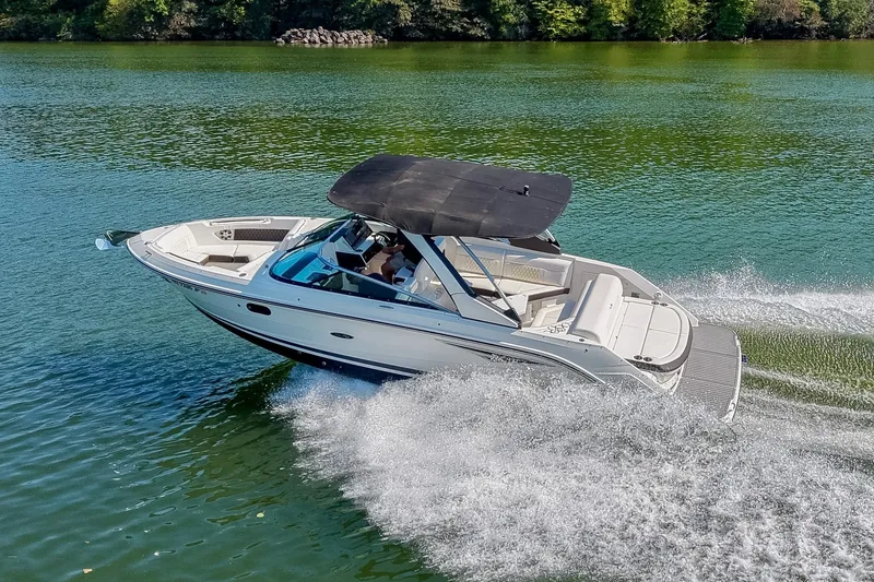Slide: The Image of 2019 Sea Ray SLX 280 cruising on a serene lake with lush green surroundings. - 10