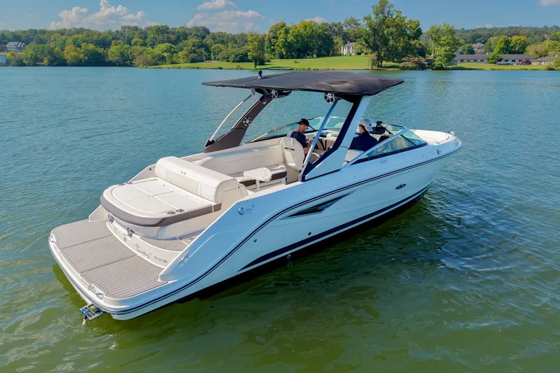 Slide: The Image of 2019 Sea Ray SLX 280 boat cruising on a serene lake under a clear blue sky. - 8