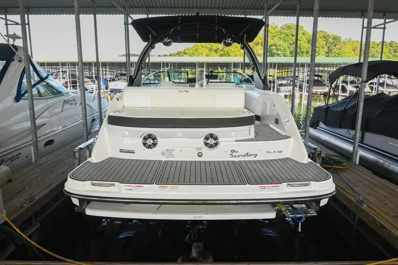 Slide: The Image of 2019 Sea Ray SLX 280 boat docked in a marina, showcasing its sleek design and spacious deck. - 12
