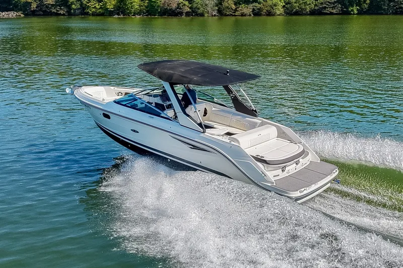 Slide: The Image of 2019 Sea Ray SLX 280 cruising on a serene lake with lush green surroundings. - 1