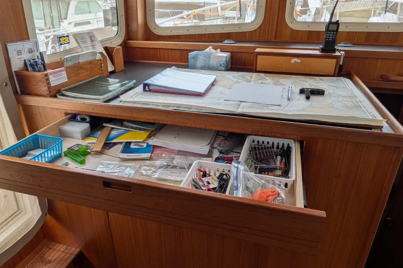 Slide: The Image of Navigation station on a 2003 Nordic Tug 37 with maps and supplies. - 29