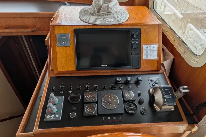 Slide: The Image of Control panel of a 2003 Nordic Tug 37 with navigation and throttle controls. - 23