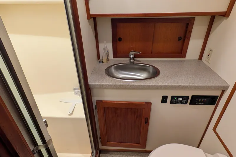 Slide: The Image of 2003 Nordic Tug 37 bathroom with sink, wooden cabinets, and shower area. - 39