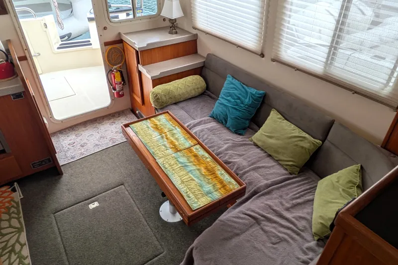 Slide: The Image of Cozy interior of a 2003 Nordic Tug 37 with colorful cushions and a decorative table. - 18