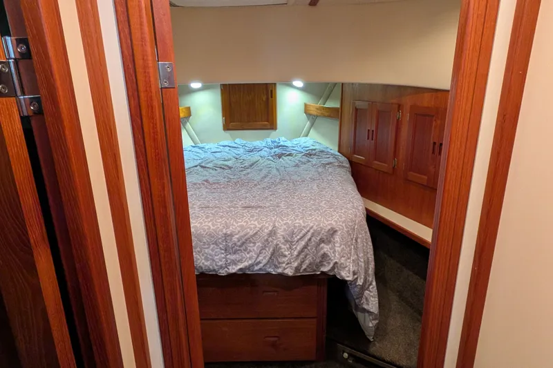 Slide: The Image of Cozy bedroom interior of 2003 Nordic Tug 37 with wooden cabinetry and soft lighting. - 33