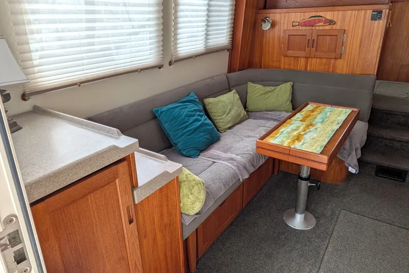 Slide: The Image of Cozy interior of 2003 Nordic Tug 37 with cushioned seating and decorative table. - 14
