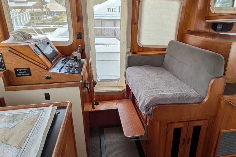 Slide: The Image of Interior of a 2003 Nordic Tug 37, featuring helm controls and a cushioned seat. - 30