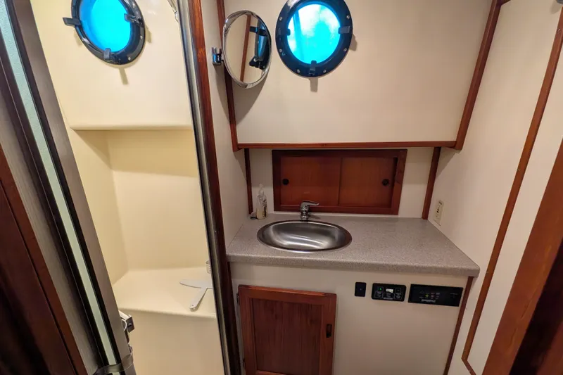 Slide: The Image of 2003 Nordic Tug 37 bathroom with sink, porthole, and shower area. - 40
