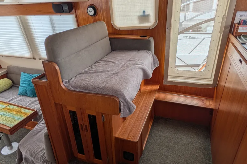Slide: The Image of Interior of a 2003 Nordic Tug 37, featuring cozy seating and wooden accents. - 31