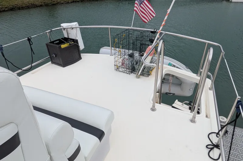 Slide: The Image of Nordic Tug 37 (2003) deck with seating, American flag, and storage cage. - 10