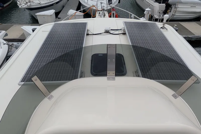 Slide: The Image of 2003 Nordic Tug 37 with solar panels on the roof, docked at a marina. - 9
