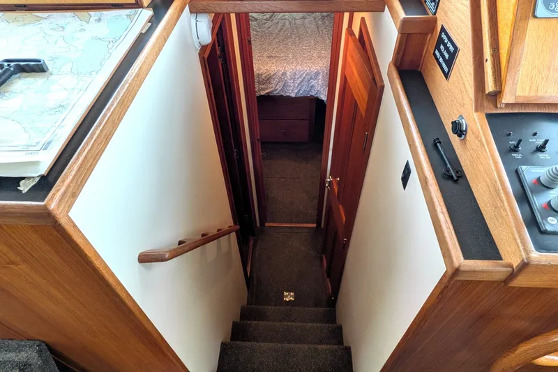 Slide: The Image of Stairway inside 2003 Nordic Tug 37, featuring wooden accents and navigational equipment. - 32