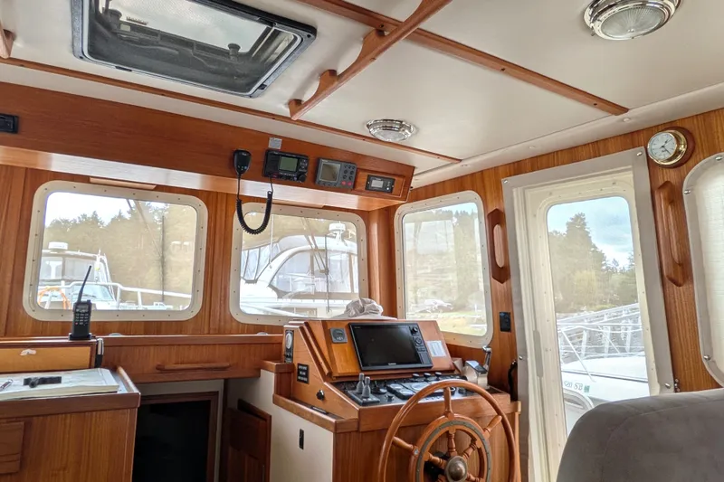 Slide: The Image of Interior of 2003 Nordic Tug 37 boat with wooden helm and navigation equipment. - 21
