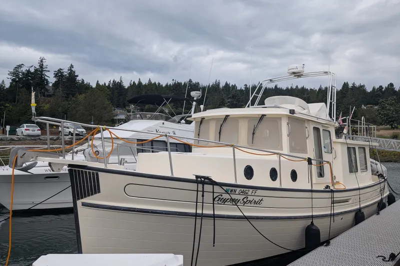 Slide: The Image of 2003 Nordic Tug 37 docked, surrounded by serene waters and lush greenery. - 3