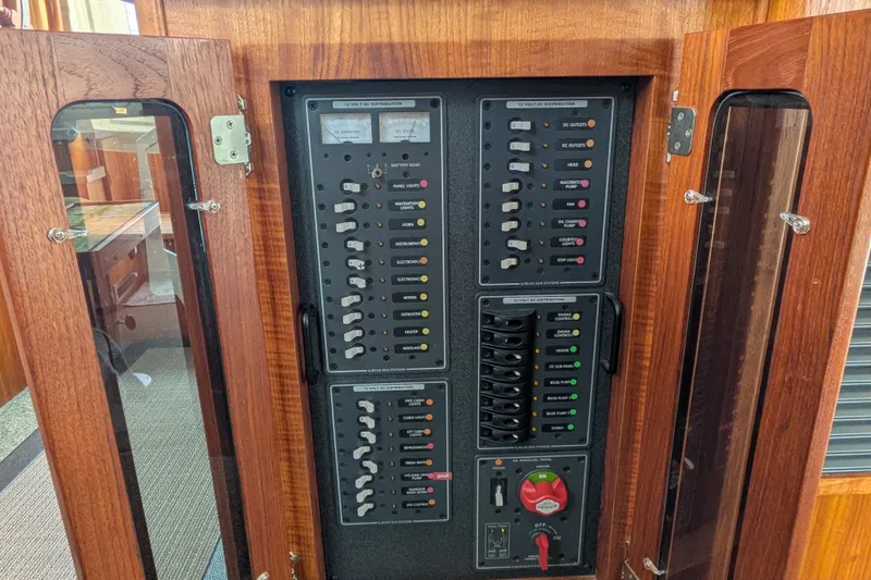 Slide: The Image of Electrical panel inside a 2003 Nordic Tug 37 boat, featuring switches and gauges. - 25