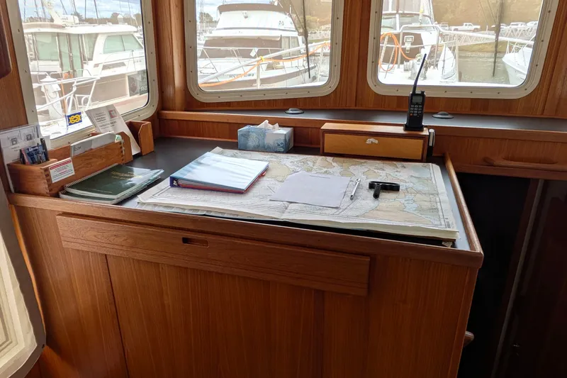 Slide: The Image of Navigation station on a 2003 Nordic Tug 37 with maps and marine equipment. - 28