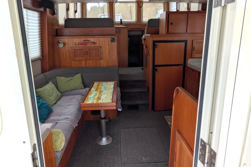 Slide: The Image of Cozy interior of a 2003 Nordic Tug 37 with wood accents and comfortable seating. - 11