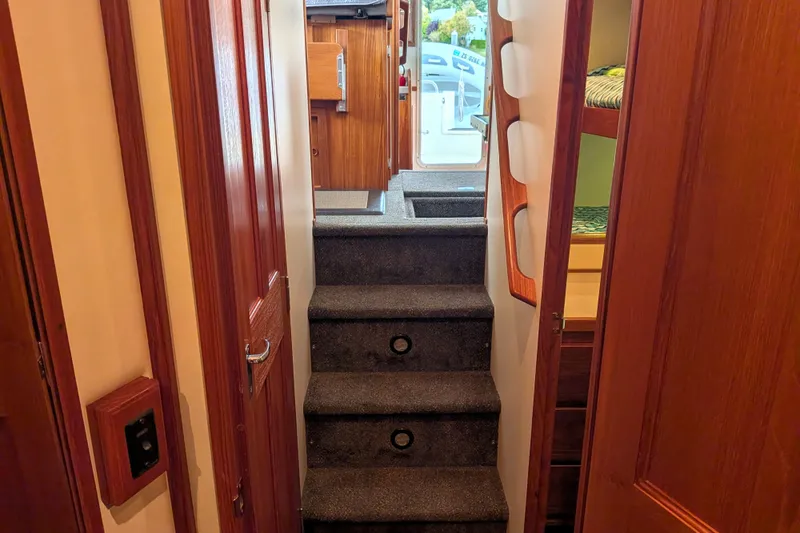 Slide: The Image of Interior view of 2003 Nordic Tug 37, featuring carpeted stairs and wooden paneling. - 45