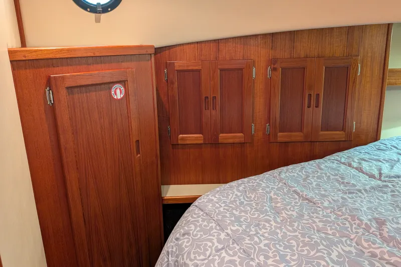 Slide: The Image of Interior of 2003 Nordic Tug 37 with wooden cabinets and patterned bedding. - 43