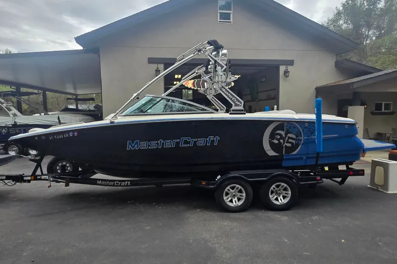 Slide: The Image of 2008 MasterCraft X-35 boat on trailer, parked outside a garage. - 17