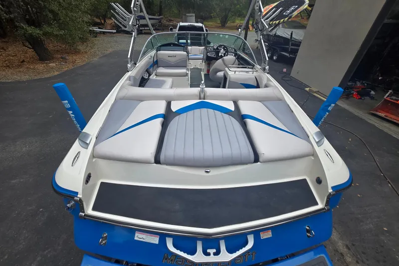 Slide: The Image of 2008 MasterCraft X-35 boat with blue and gray seating, parked outdoors. - 5