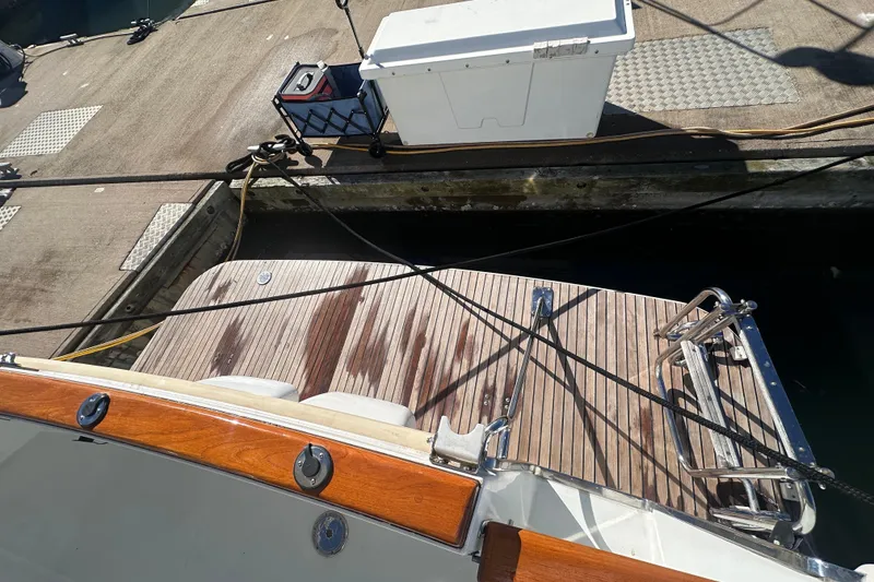 Slide: The Image of Beneteau Swift Trawler 34, 2011, docked with wooden deck and mooring lines. - 18