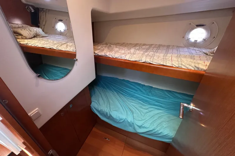 Slide: The Image of 2011 Beneteau Swift Trawler 34 cabin with bunk beds and porthole window. - 59