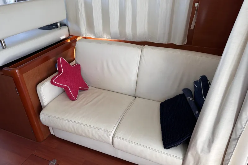 Slide: The Image of Interior of 2011 Beneteau Swift Trawler 34 with white sofa and star-shaped pillow. - 33