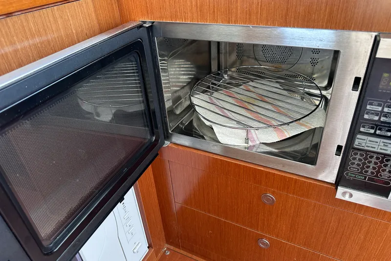 Slide: The Image of Microwave oven inside 2011 Beneteau Swift Trawler 34, featuring wooden cabinetry. - 39