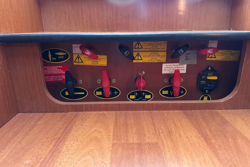 Slide: The Image of Control panel of a 2011 Beneteau Swift Trawler 34 with switches and caution labels. - 62
