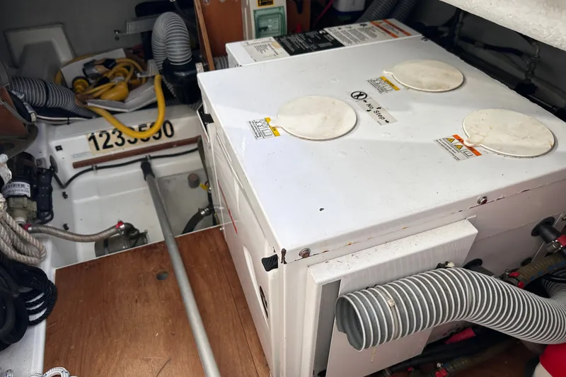 Slide: The Image of Engine room of a 2011 Beneteau Swift Trawler 34 with equipment and hoses visible. - 73