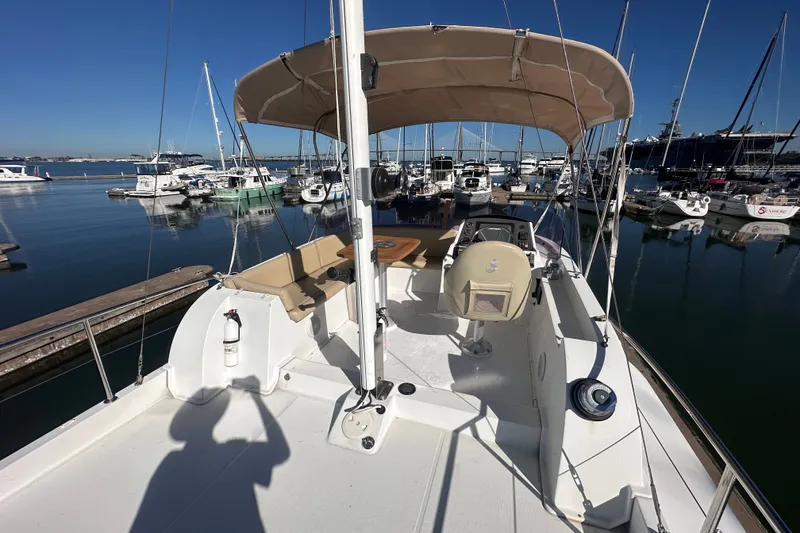 Slide: The Image of 2011 Beneteau Swift Trawler 34 at marina, featuring helm and seating area under canopy. - 19