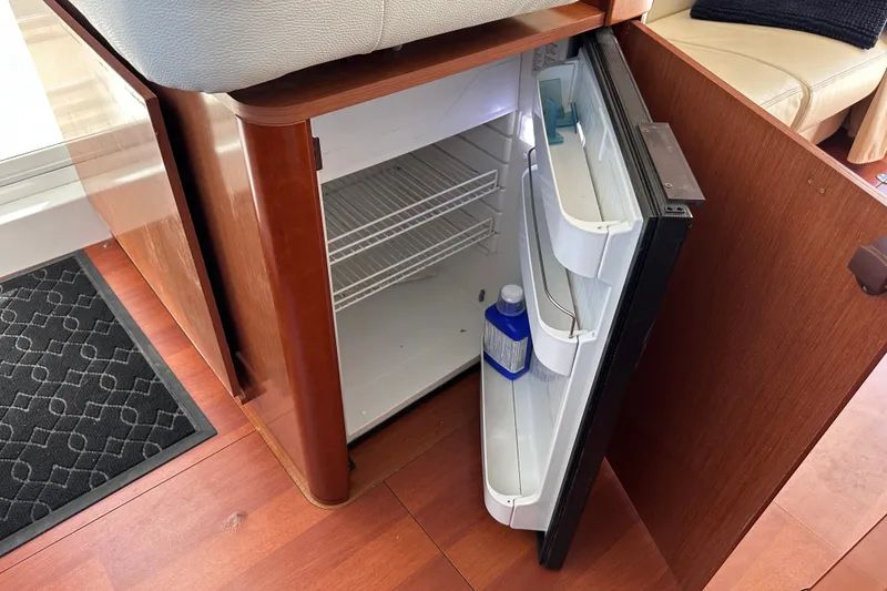 Slide: The Image of Open fridge inside 2011 Beneteau Swift Trawler 34, showcasing interior storage space. - 44