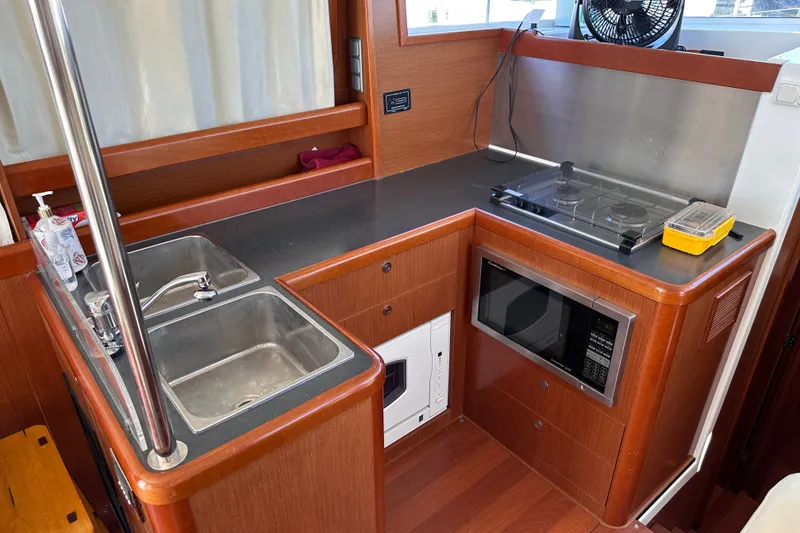 Slide: The Image of Galley kitchen in 2011 Beneteau Swift Trawler 34 with sink, stove, and microwave. - 37