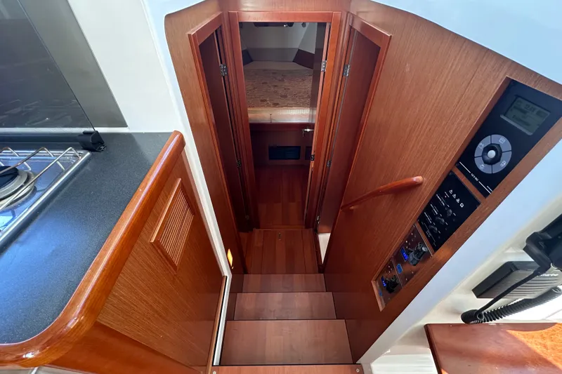 Slide: The Image of Interior view of 2011 Beneteau Swift Trawler 34, featuring wooden stairs and control panel. - 55
