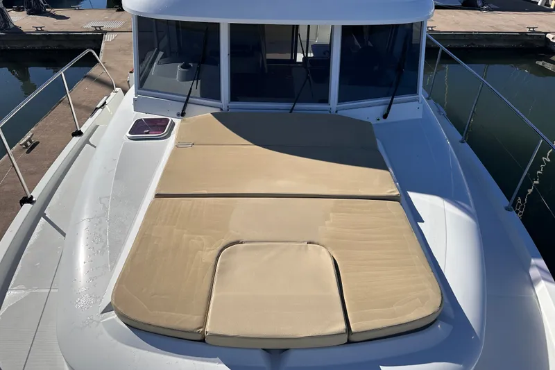 Slide: The Image of 2011 Beneteau Swift Trawler 34 with sunpad on deck, docked at marina. - 14