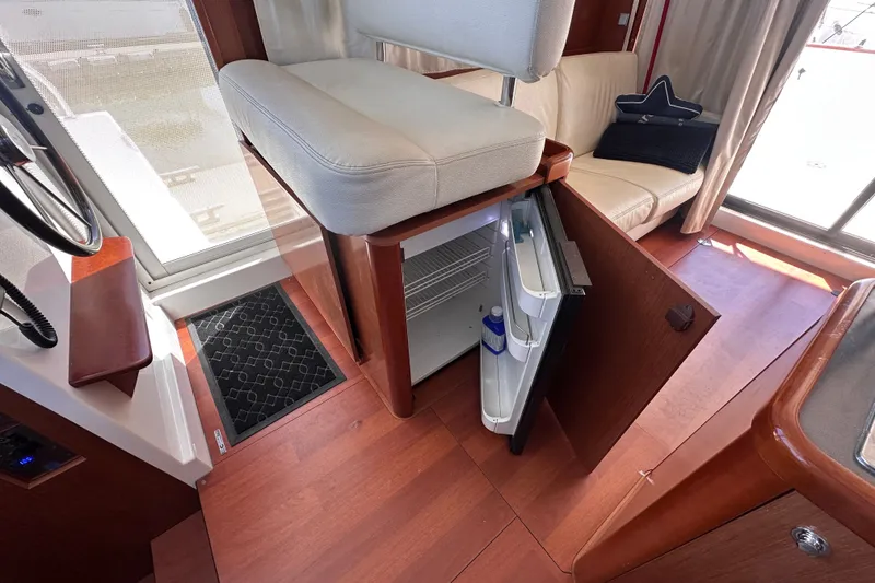 Slide: The Image of Interior of 2011 Beneteau Swift Trawler 34 with open mini fridge and seating area. - 43