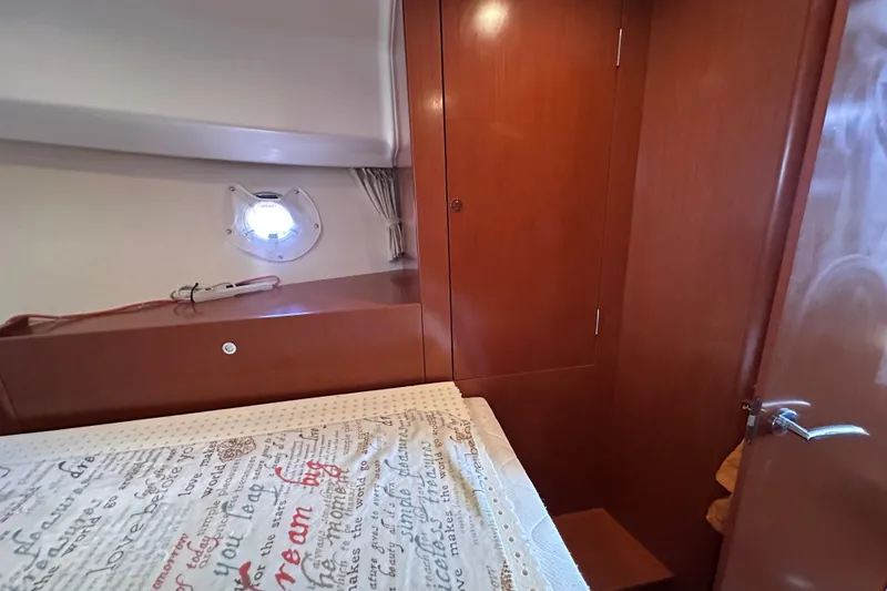 Slide: The Image of Cozy cabin interior of 2011 Beneteau Swift Trawler 34 with wooden cabinetry and porthole. - 66