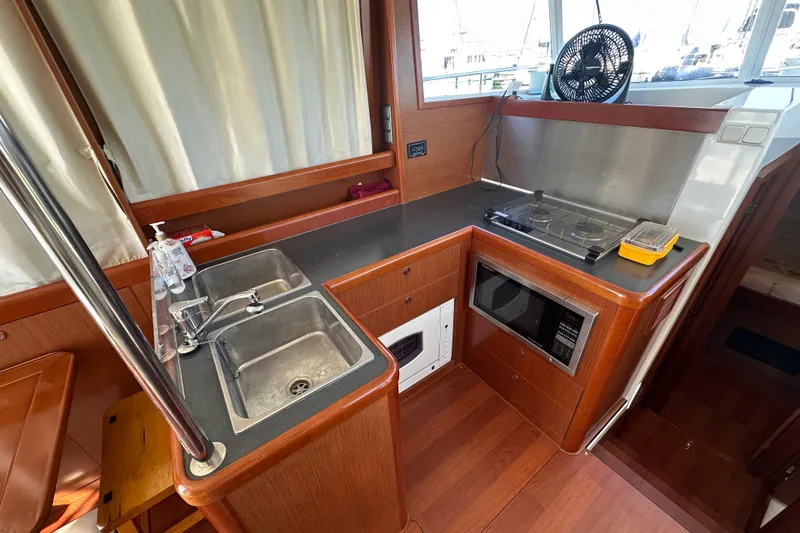 Slide: The Image of 2011 Beneteau Swift Trawler 34 kitchen with sink, stove, and microwave. - 36