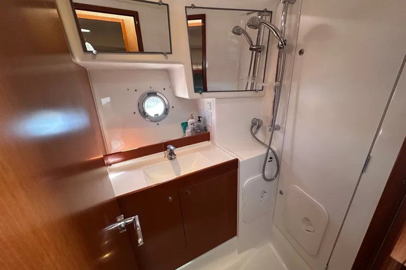 Slide: The Image of Bathroom of 2011 Beneteau Swift Trawler 34 with shower, sink, and porthole window. - 60